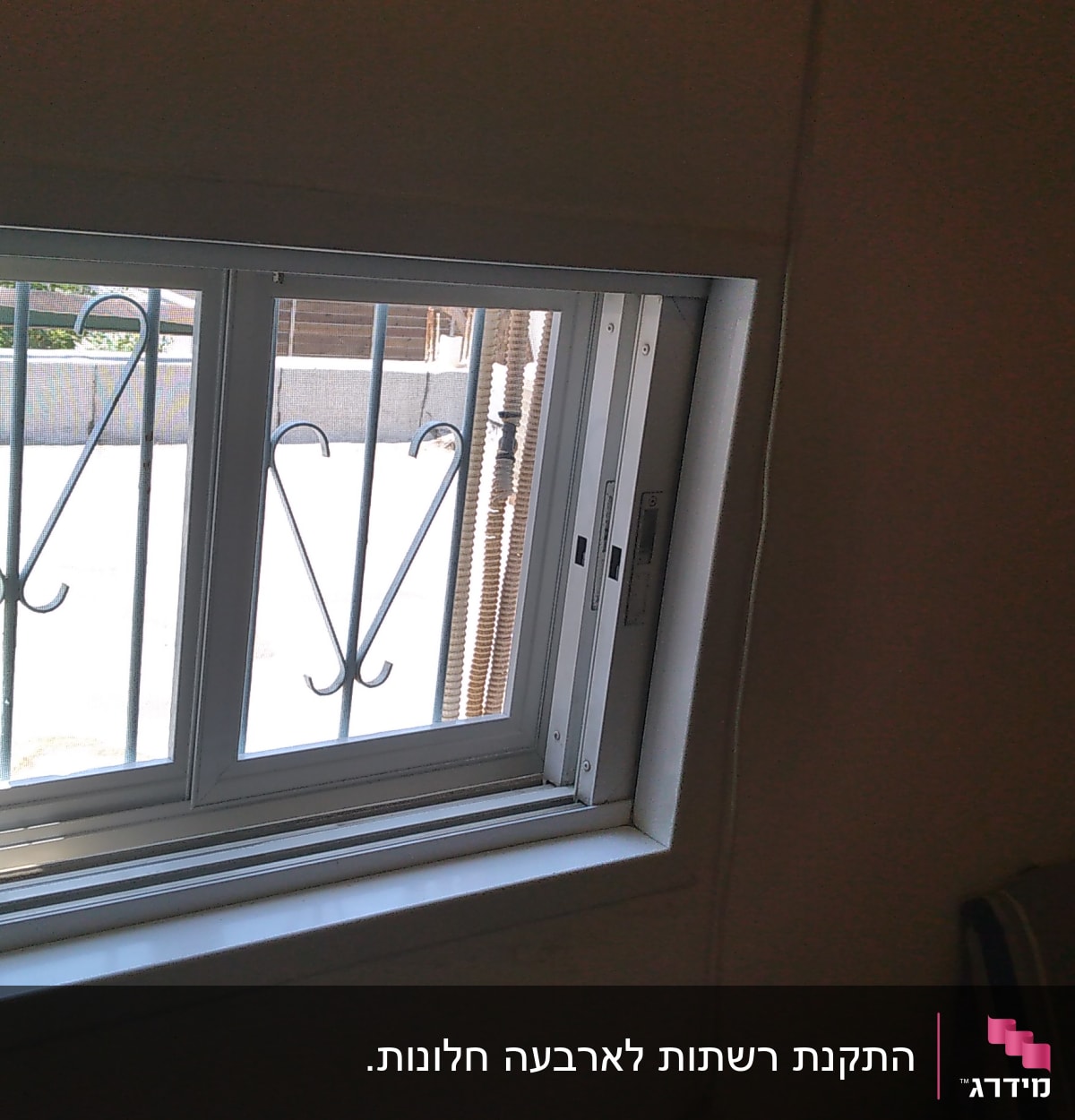 חלון אלומיניום עם מסגרת לבנה וסורגים